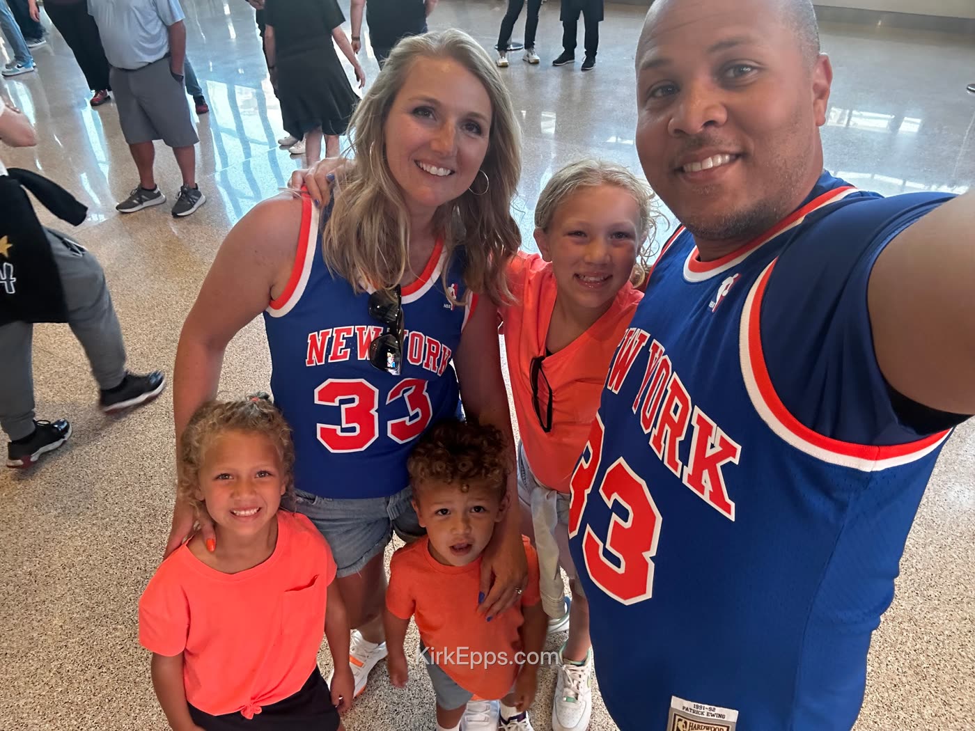 Kirk and his family in matching New York basketball jerseys at a game