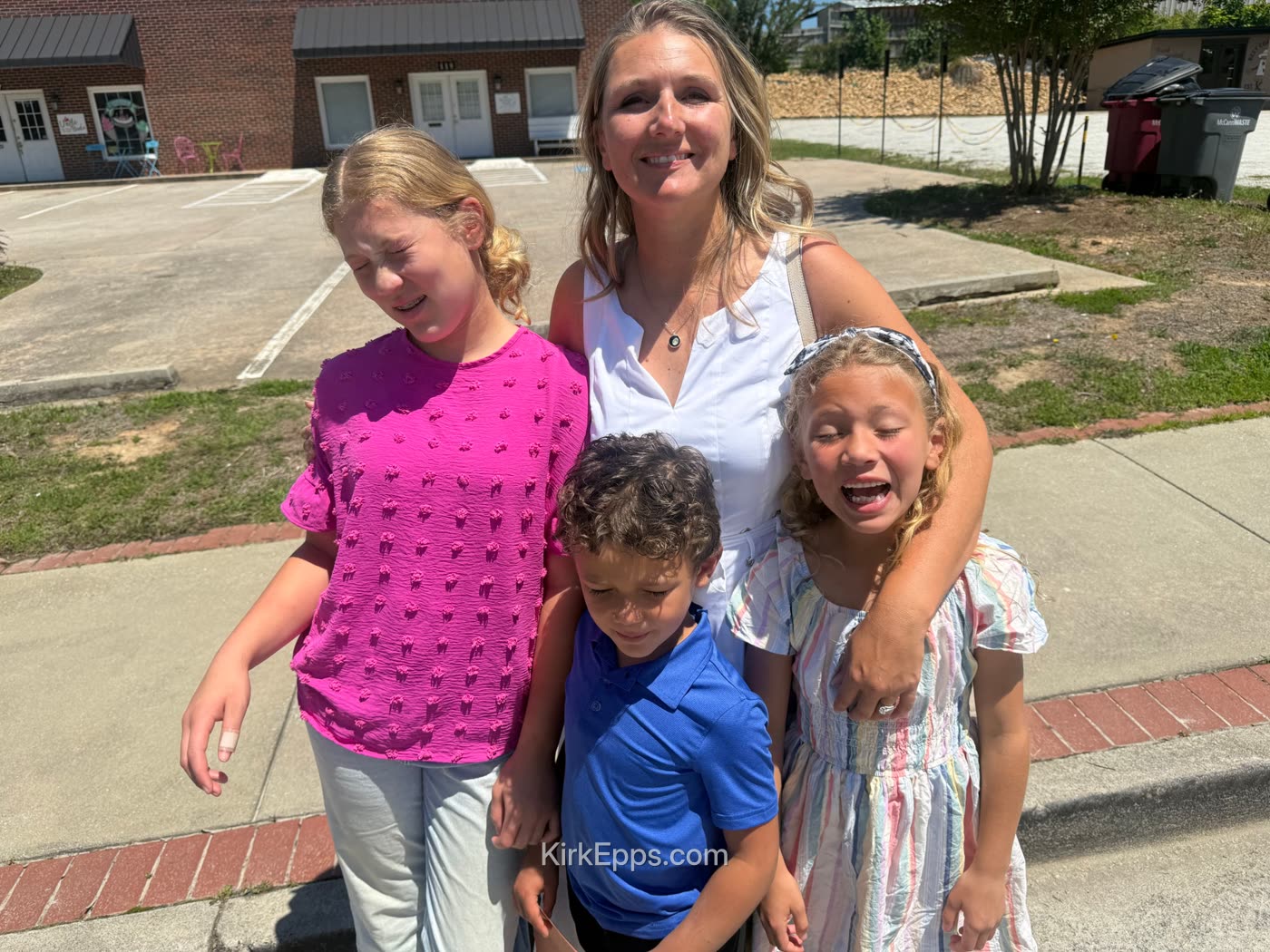 Kirk's wife with their three kids on a sunny day